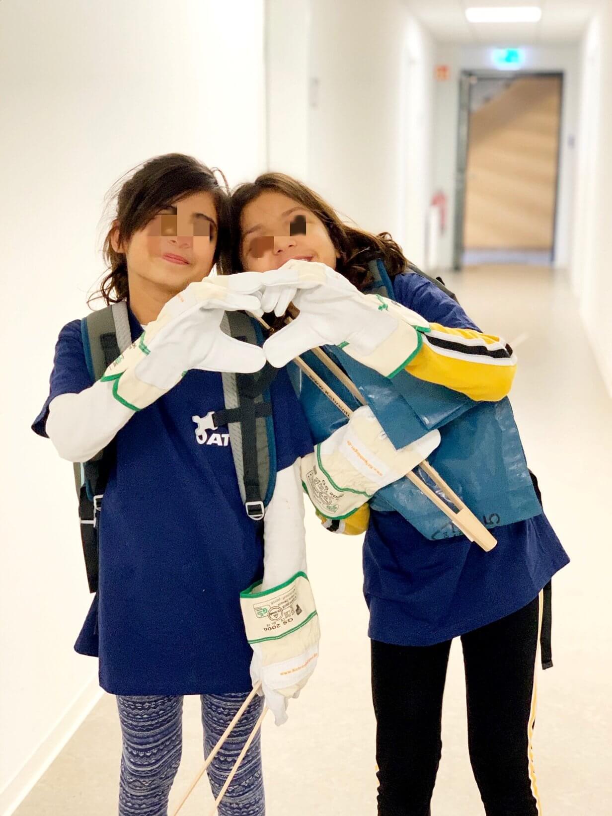 Children in cleaning gear show heart symbol