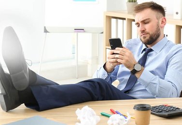 man sitting on table with mobile phone