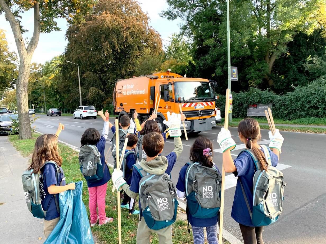 Children wave to rubbish truck