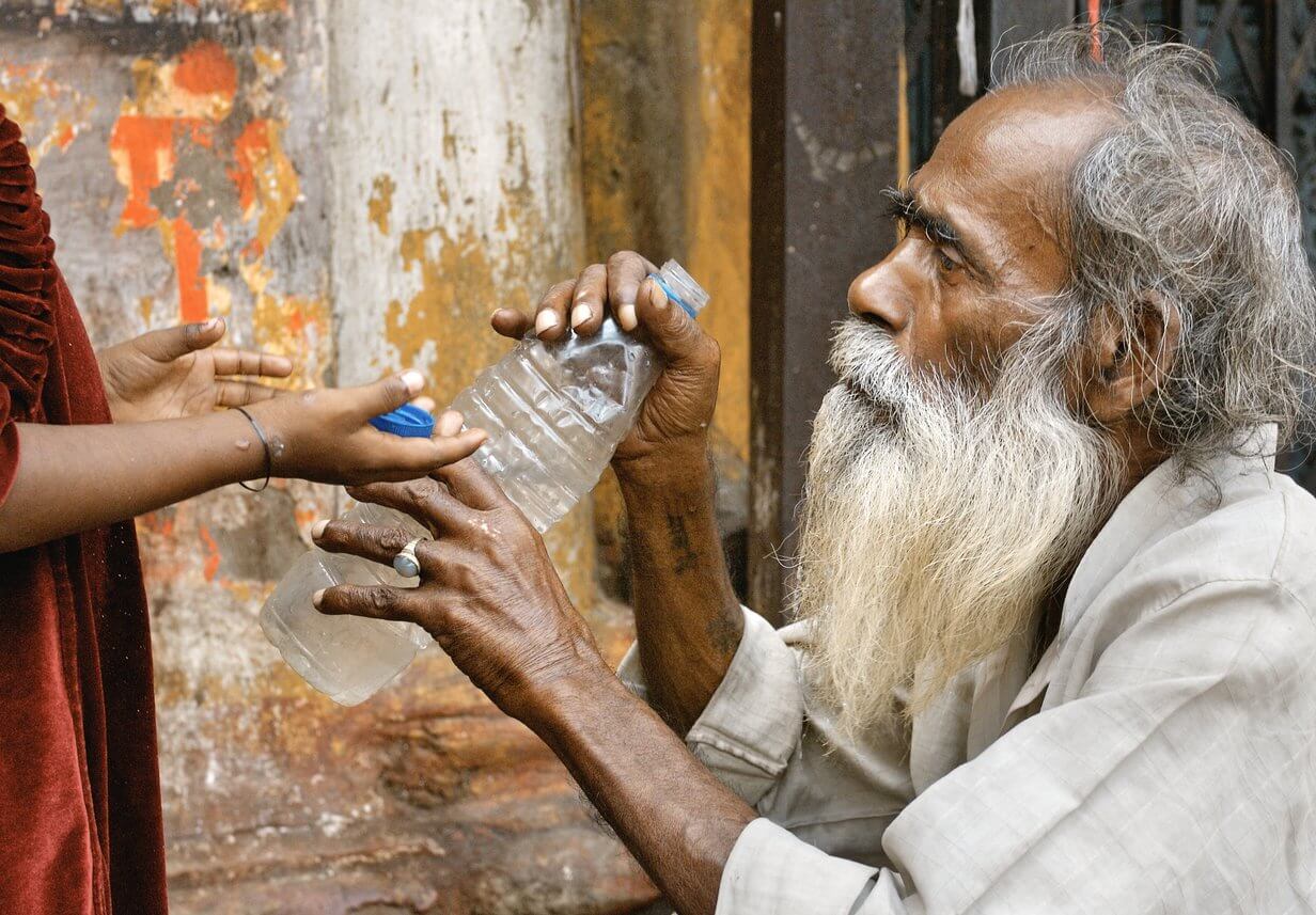Un homme âgé se voit tendre une bouteille d'eau en plastique