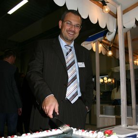 Ceremonia de inauguración del edificio de la empresa reconvertido. Una tarta en primer plano